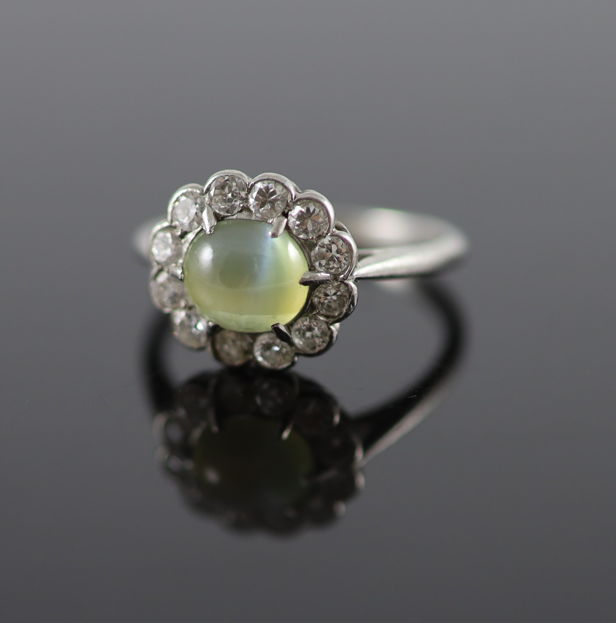 A 1920's/1930's platinum, cats eye chrysoberyl and diamond set oval cluster ring